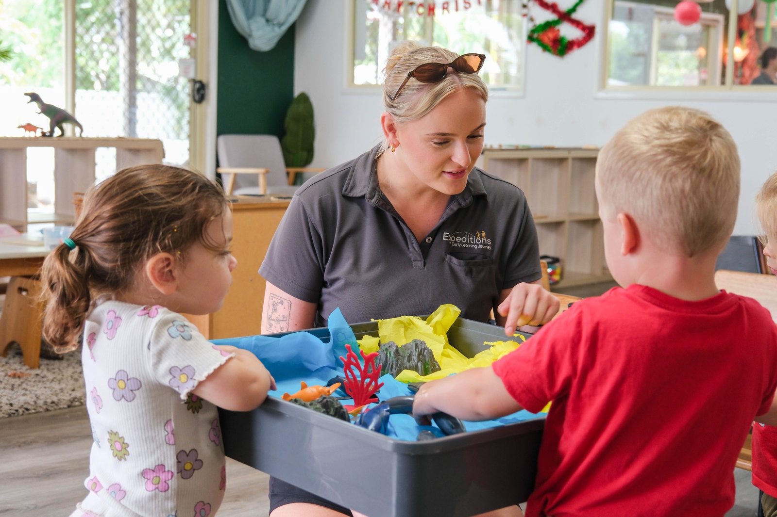 An educator and children exploring a sensory table at Expeditions Avoca