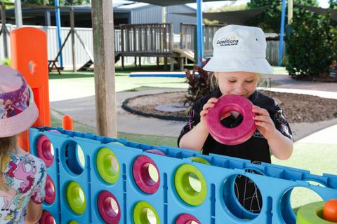 A child exploring a colourful outdoor play panel at Expeditions Avoca