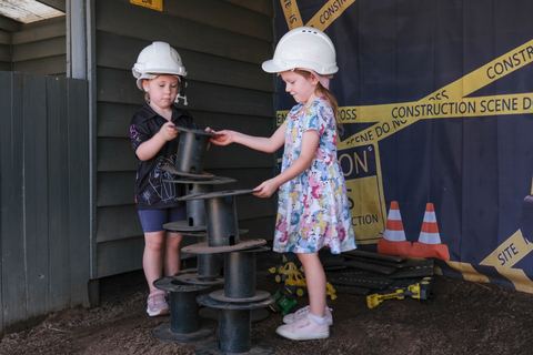 Children exploring a construction-themed outdoor play area at Expeditions Avoca