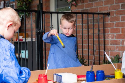 A child exploring paint with a brush at Expeditions Avoca