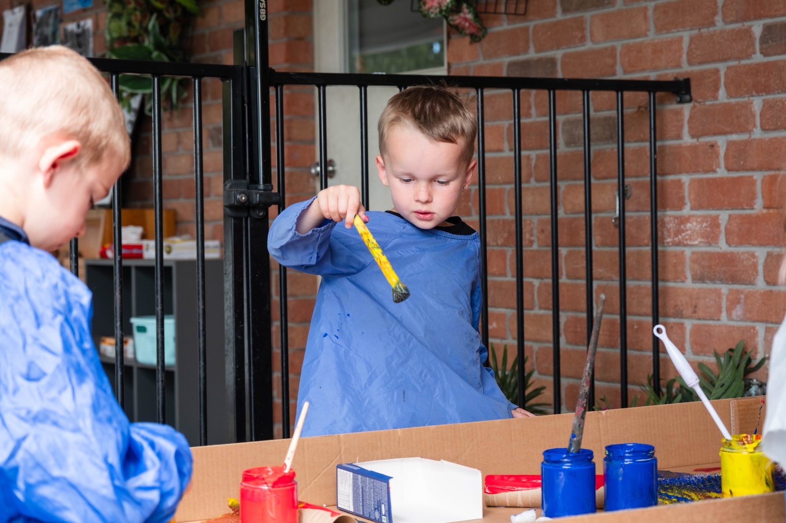 A child exploring paint with a brush at Expeditions Avoca