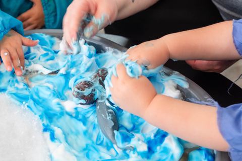 Hands exploring blue sensory materials at Expeditions Avoca