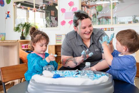 An educator and children playing at a sensory tray at Expeditions Avoca