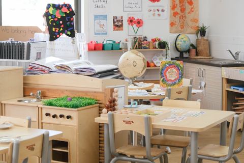 A learning room with child-height tables and open shelves at Expeditions Narre Warren