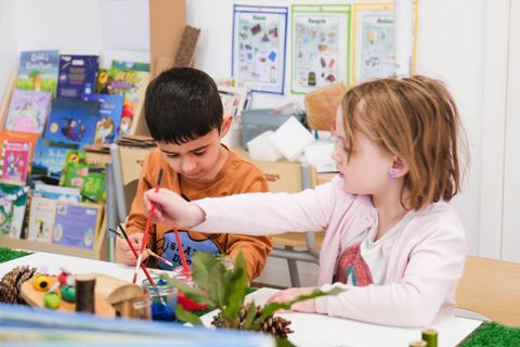 Children exploring materials together at a table at Expeditions Narre Warren