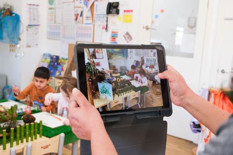 An adult documenting a shared learning experience at Expeditions Narre Warren