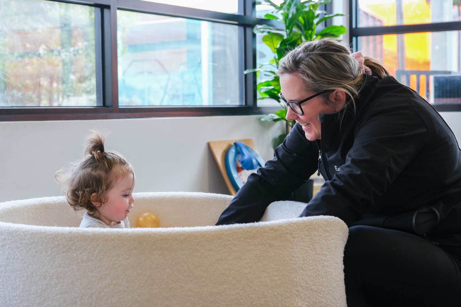 An educator sharing time with a child indoors at Expeditions Officer