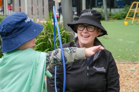 An educator and children exploring outdoors at Expeditions Officer