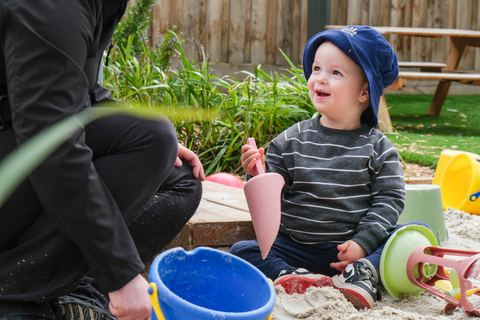 A child playing with sand and toys outdoors at Expeditions Officer