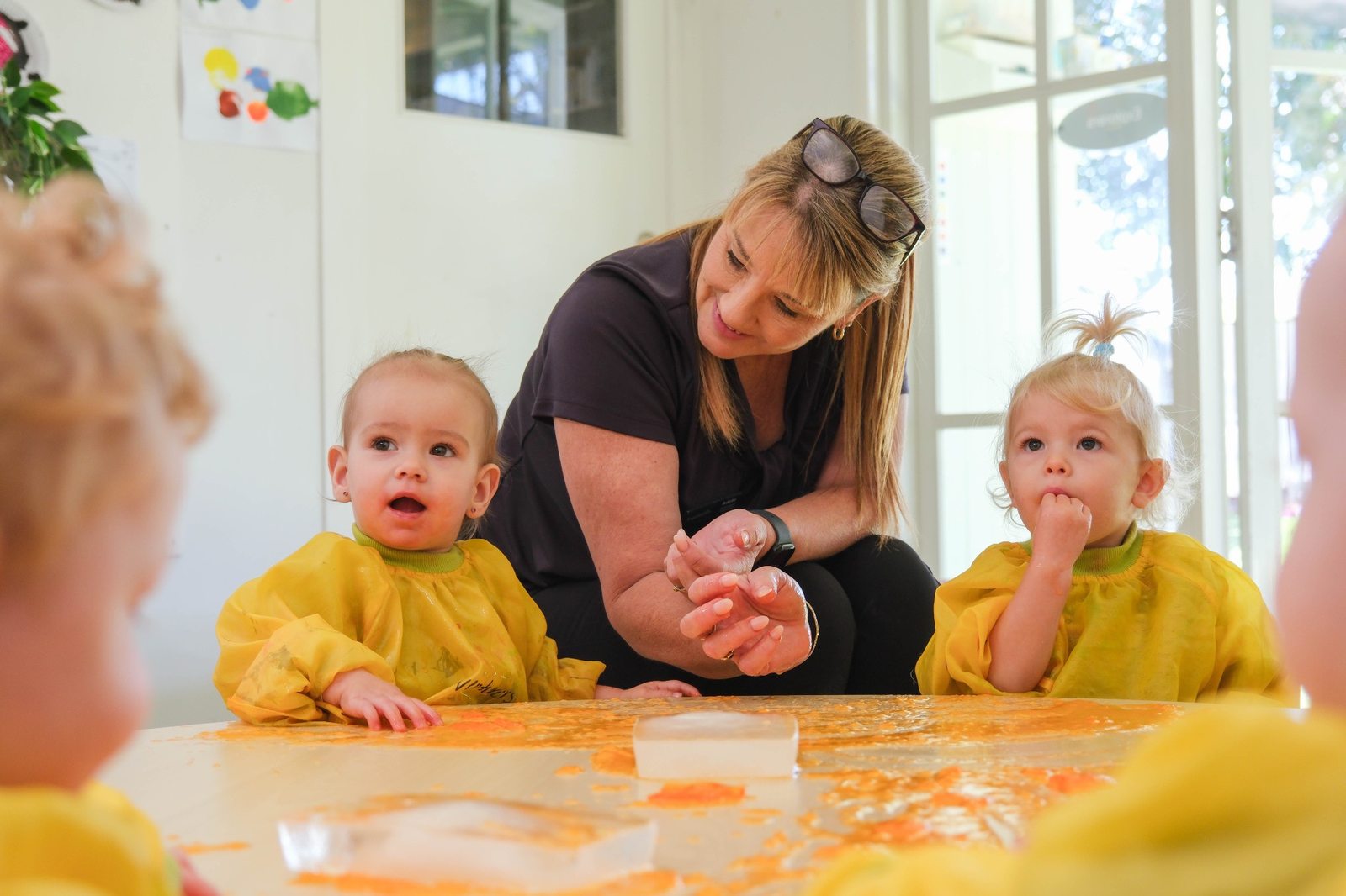 An educator and young children exploring sensory play at Expeditions Raceview