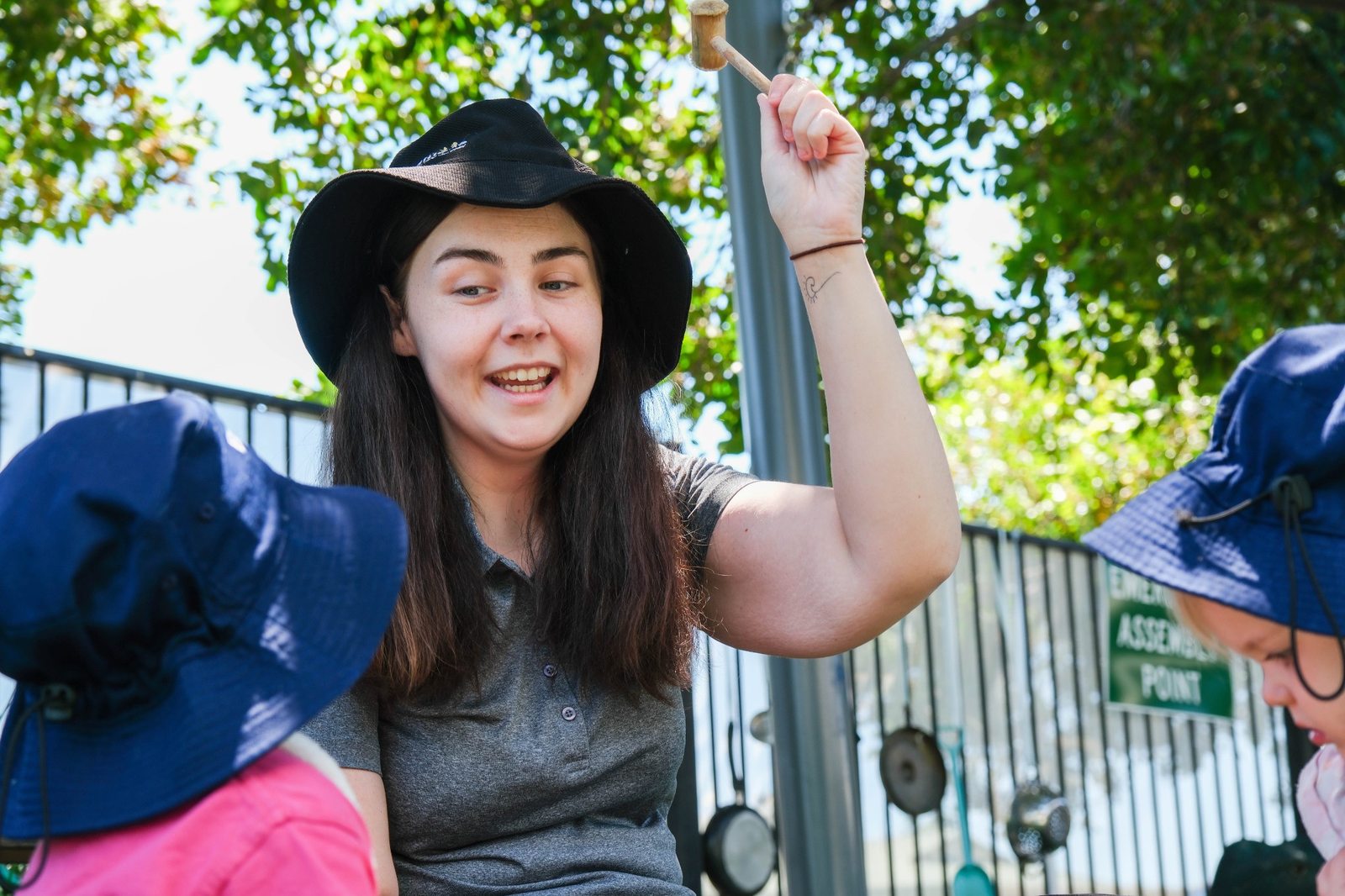 An educator and children gathering outdoors at Expeditions Raceview