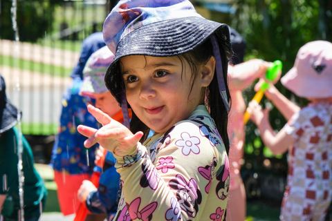 A child enjoying outdoor water play at Expeditions Raceview