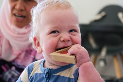 A young child exploring a wooden toy at Expeditions Raceview