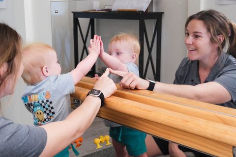 An educator engaging with young children beside a mirror at Expeditions Raceview