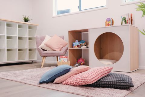 A cosy reading nook with cushions and low shelving at Expeditions Raceview 2