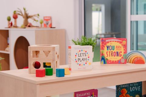 Books and colourful play materials on a low shelf at Expeditions Raceview 2