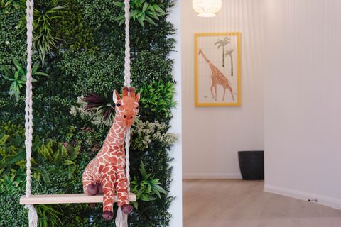 A decorative giraffe beside a leafy feature wall at Expeditions Raceview 2