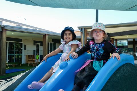 Children playing on a blue outdoor slide at Expeditions Underwood