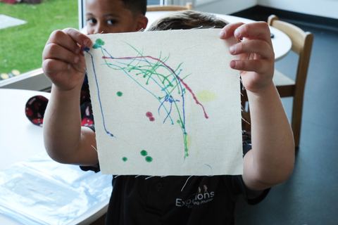 A child showing a colourful drawing at Expeditions Underwood