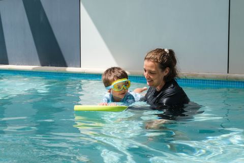 An adult supporting a child in the swimming pool at Expeditions Underwood