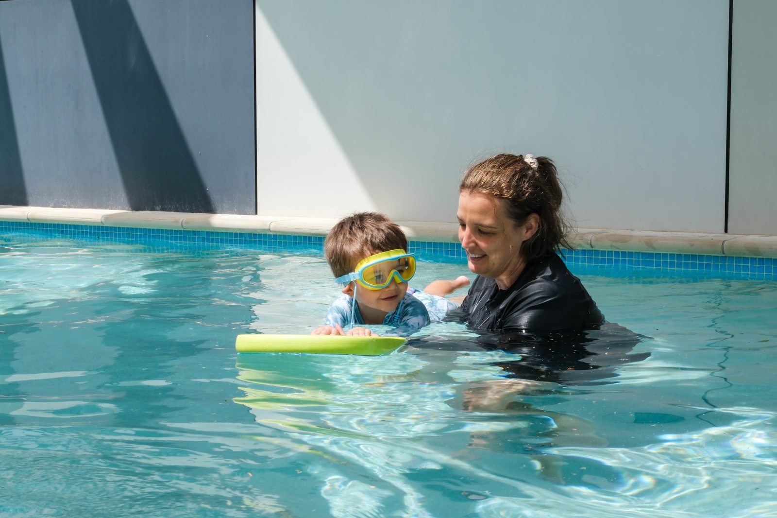 An adult supporting a child in the onsite swimming pool at Expeditions Underwood