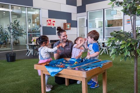 An educator and children gathered around a sensory table at Expeditions Underwood