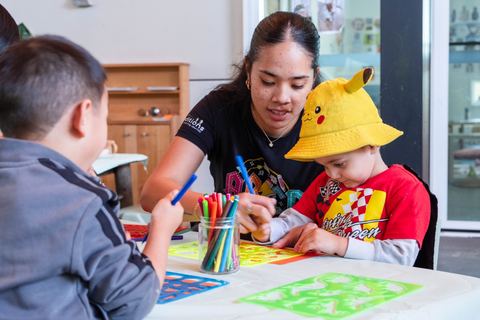 An educator supporting children with drawing at Expeditions Underwood